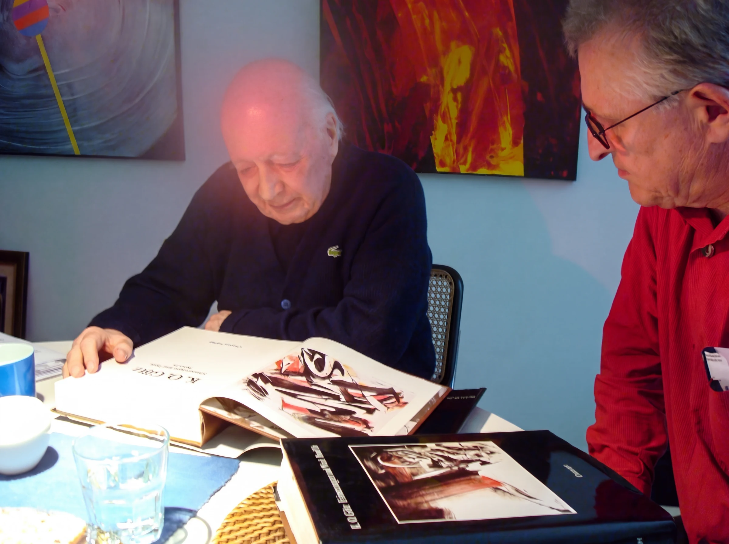 Hilko Weerda und K. O. Götz betrachten gemeinsam ein aufgeschlagenes Kunstbuch, 2008.